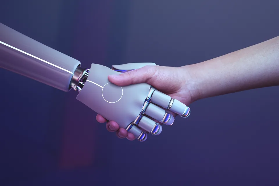 An Image showing handshake between a human and a robot — a symbolic gesture of collaboration between human intelligence and artificial intelligence.